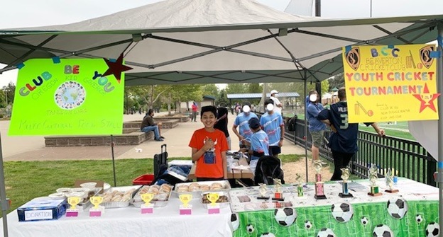Taneesh stands at a table displaying trophies