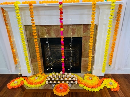 Strings of flower blossoms adorn the front sides and floor in front of a fireplace.