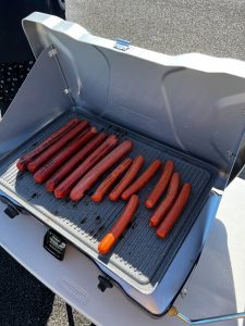 13 hot dogs on a grill