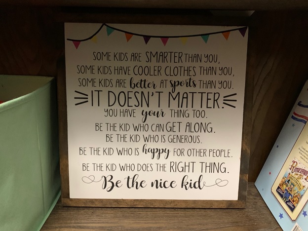 Sign reads: Some kids are smarter than you, some kids have cooler clothes than you, some kids are better at sports than you. It doesn't matter. You have your thing too. Be the kid who can get along. Be the kid who is generous. Be the kid who is happy for other people. Be the kid who does the right thing. Be the nice kid.